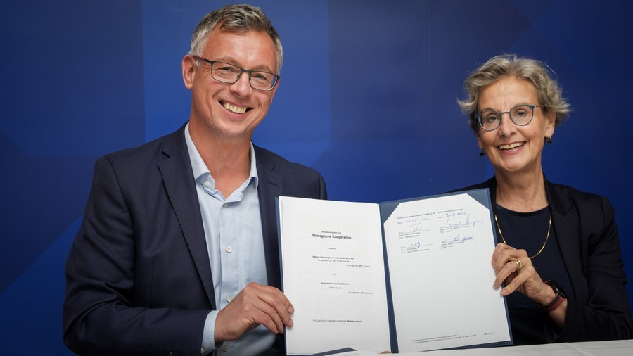 photo of Raik Brettschneider (Vice President & Managing Director of Infineon Dresden) and Prof. Ursula M. Staudinger (Rector of TUD) presenting the signed agreement of cooperation