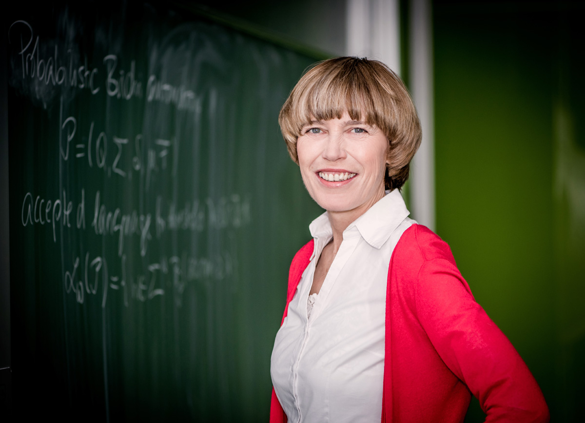 portrait photo of professor Christine Baier standing in front of a blackboard